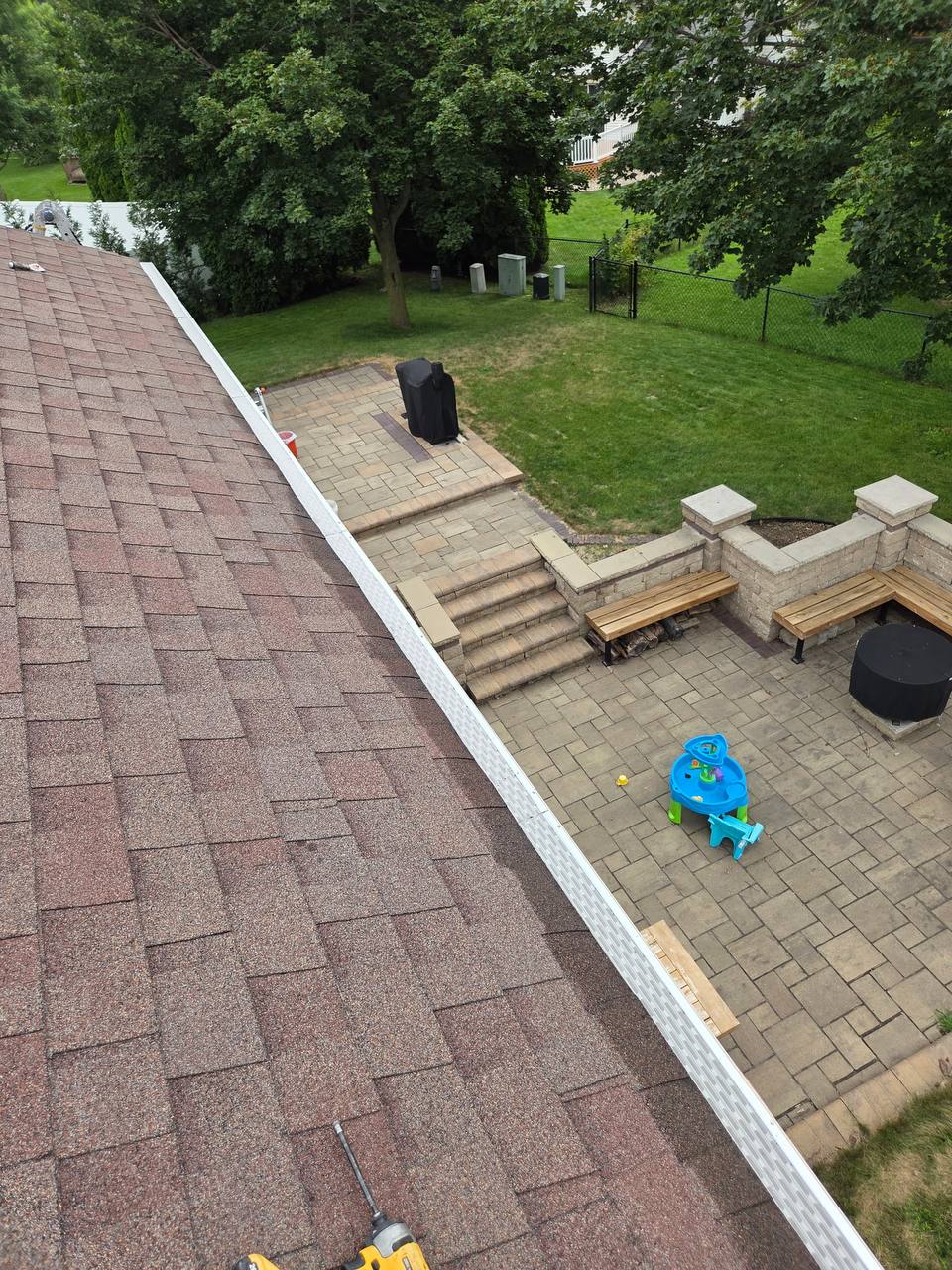 Long finished run of white micro-mesh gutter guard along a residential roofline