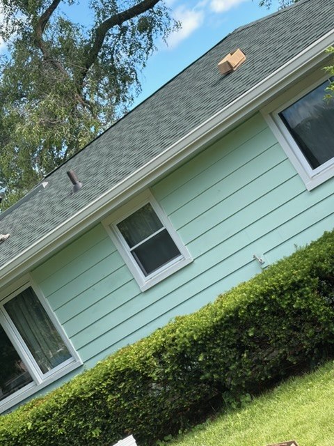 Before photo of older fascia and gutter line on a light green home before GutterForge soffit and fascia work